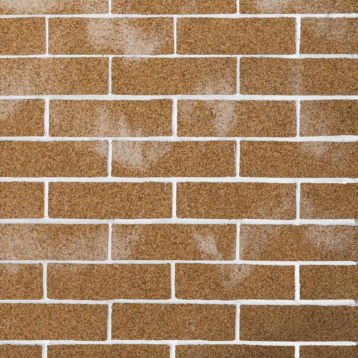 Ohebný kamenný obklad žluto-hnědé barvy s bílým žíháním, připomínající pískovec.